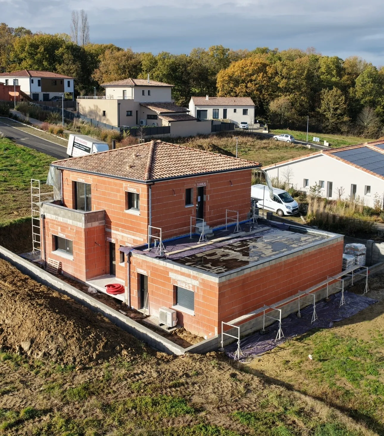 Maison en construction sous échafaudages sur un chantier suivi par GMR en Haute-Garonne.